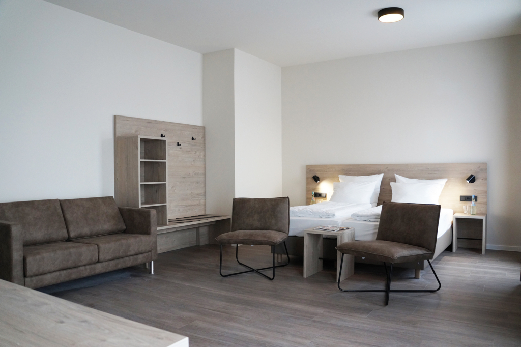 Hotel-Suite mit Bett, Sitzecke, Kofferablage und Schreibtisch